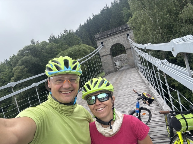 Dvojice na cyklovýletě na visutém mostě